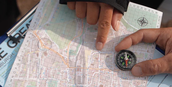 People using a map and compass to navigate a city treasure hunt