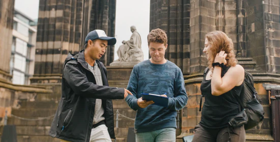 People enjoying a city treasure hunt using printed clues, a clipboard and compass