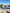 Three friends posing with arms outstretched beside a lake in a park on a sunny treasure hunt