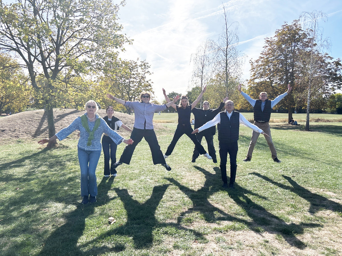 Group of friends doing star jumps together in a park on a party treasure hunt