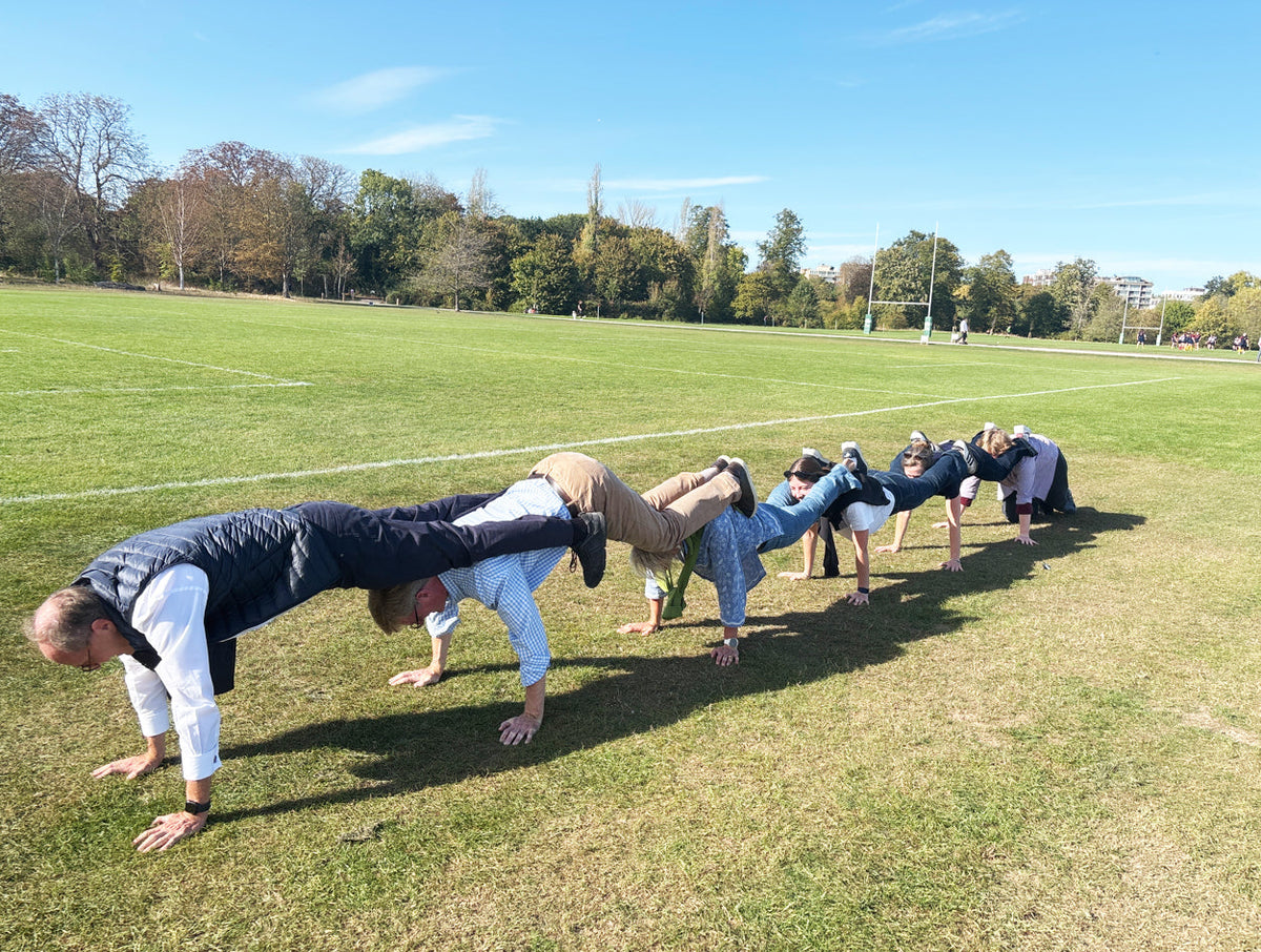 Group forming a human plank chain on a playing field for a treasure hunt photo challenge