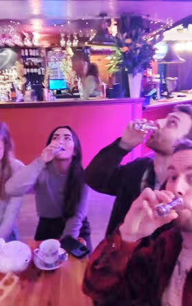 Friends taking shots together during a pub challenge on a party treasure hunt